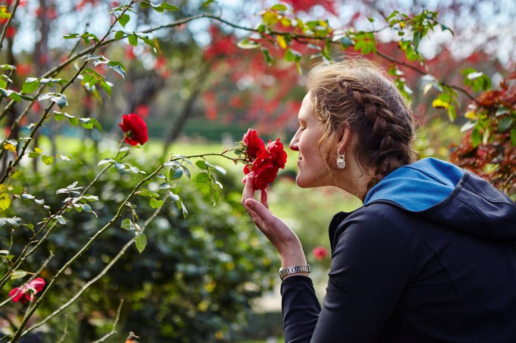 Close up of woman smelling a rose in the Formal Gardens at Enchanted Adventure